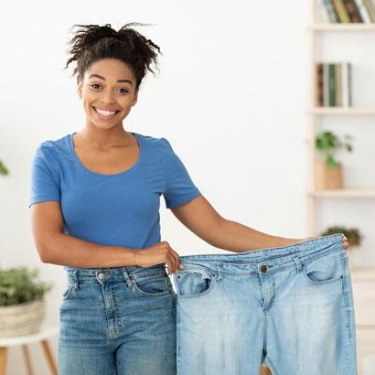 woman-holding-larger-pants-size